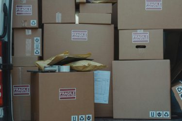 A variety of cardboard boxes labeled 'fragile' stacked in a vehicle for shipping or storage.